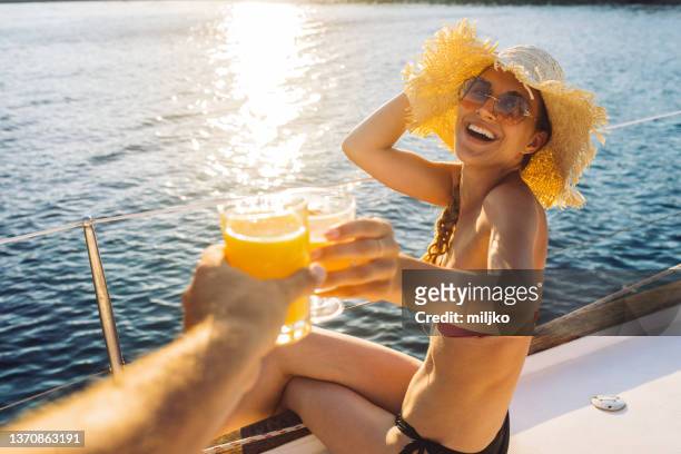 mujer joven bebiendo jugo en velero - mar jónico fotografías e imágenes de stock