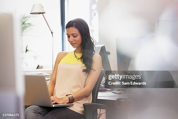 businesswoman typing on laptop in office - op schoot stockfoto's en -beelden