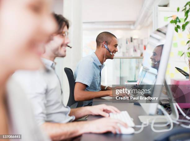 business people with headsets working at computers in office - answering stockfoto's en -beelden