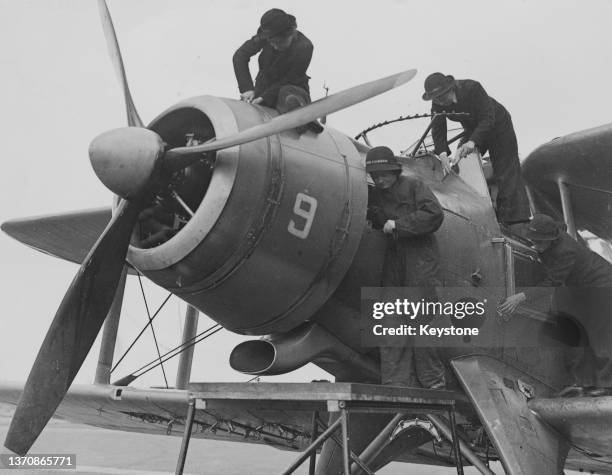 Air Mechanic Wrens of the Women's Royal Naval Service undertake maintenance on the cockpit and engine cowling of a Fleet Air Arm Fairey Albacore TB...