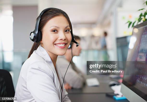 portrait of smiling businesswoman with headset at computer in office - answering email stock pictures, royalty-free photos & images