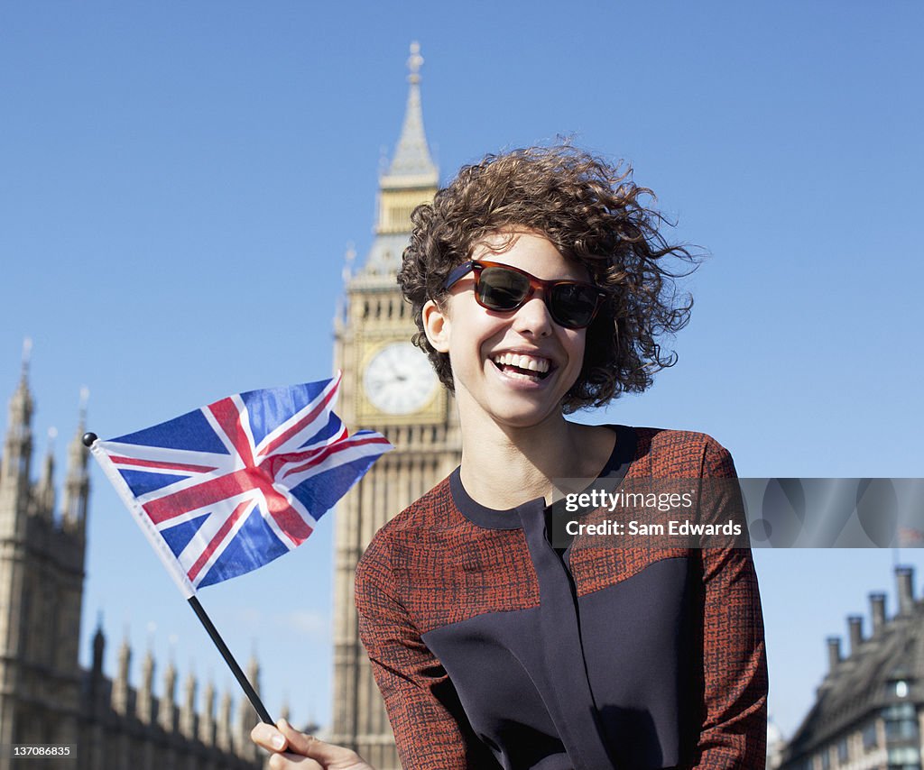 Retrato de mulher sorridente com Bandeira da Grã-Bretanha em frente