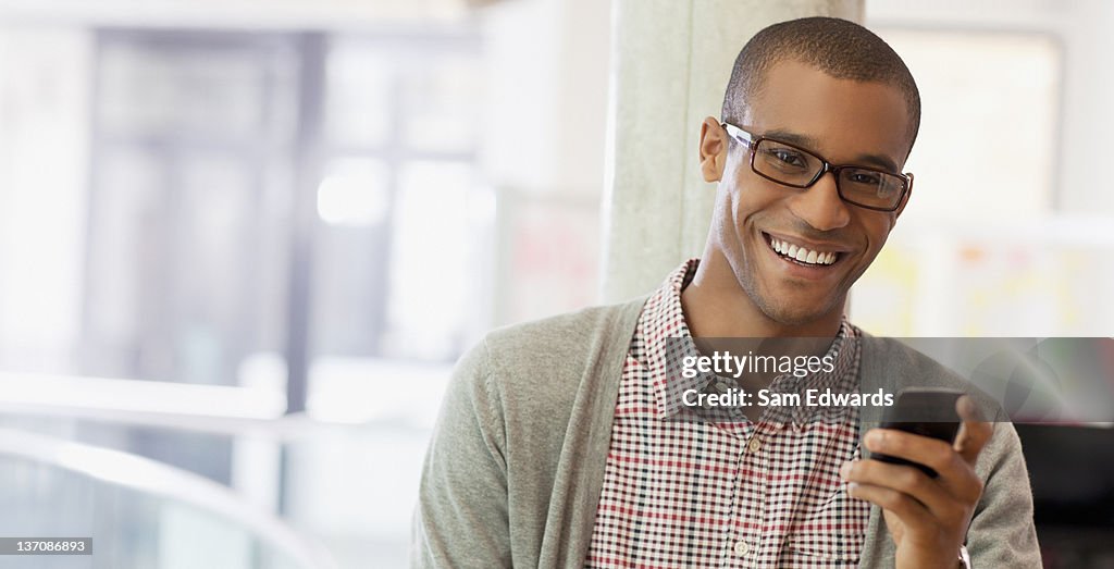Portrait of smiling businessman with cell phone