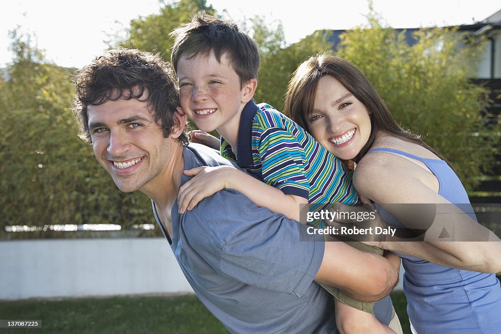 Portrait of smiling parents and son in backyard