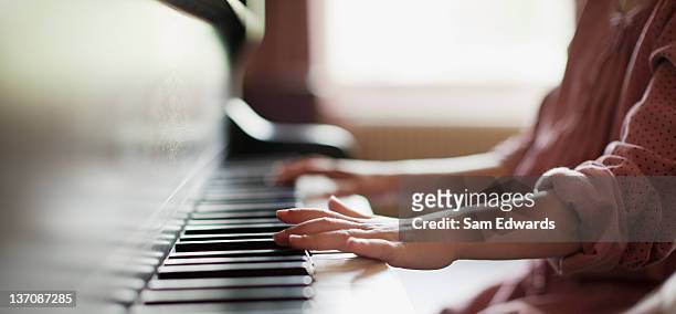 close up of girl's hands on piano - piano stock pictures, royalty-free photos & images