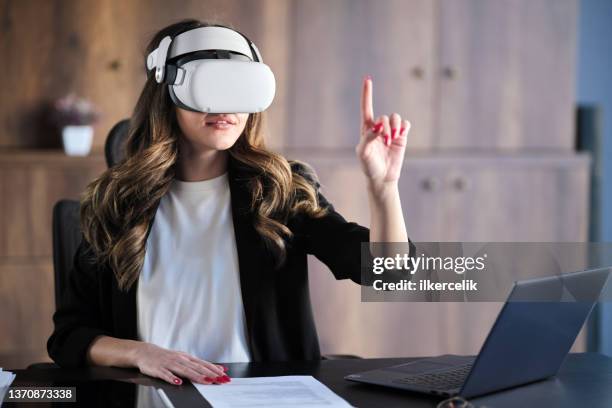 businesswoman wearing vr headset running a business meeting at home - virtual stock pictures, royalty-free photos & images