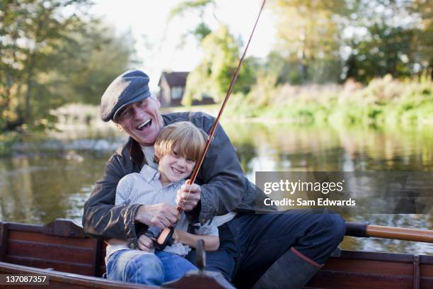 grandfather and grandson fishing in boat - salisbury stock pictures, royalty-free photos & images