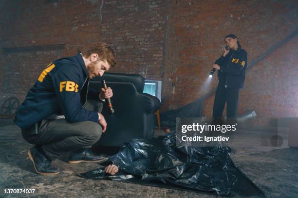 fbi agents have just found a dead body in abandoned warehouse and call to criminologists by the phone - fbi warning stock pictures, royalty-free photos & images