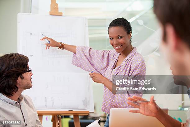 businesswoman pointing to chart in meeting - people white background stock pictures, royalty-free photos & images