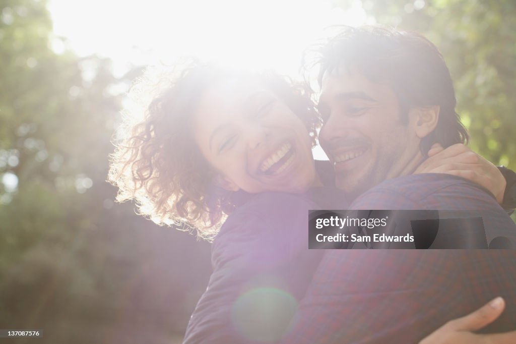 Soleil derrière couple heureux embrassant