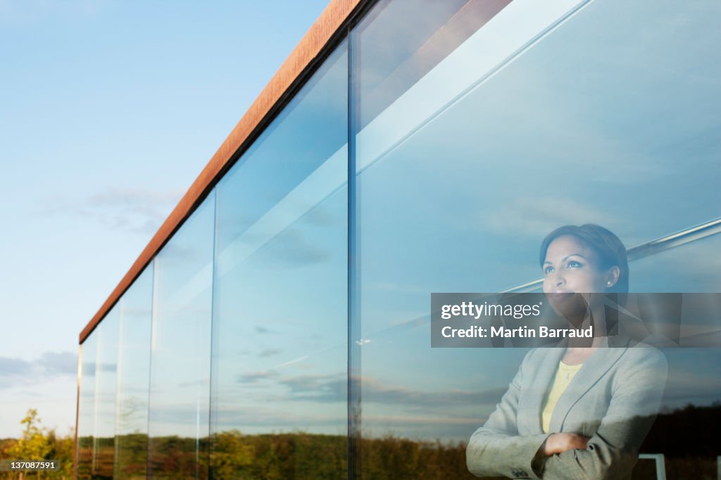 Pensive businesswoman with arms crossed in office window