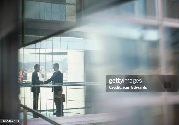 hombres de negocios estrechándose las manos - alianza fotografías e imágenes de stock