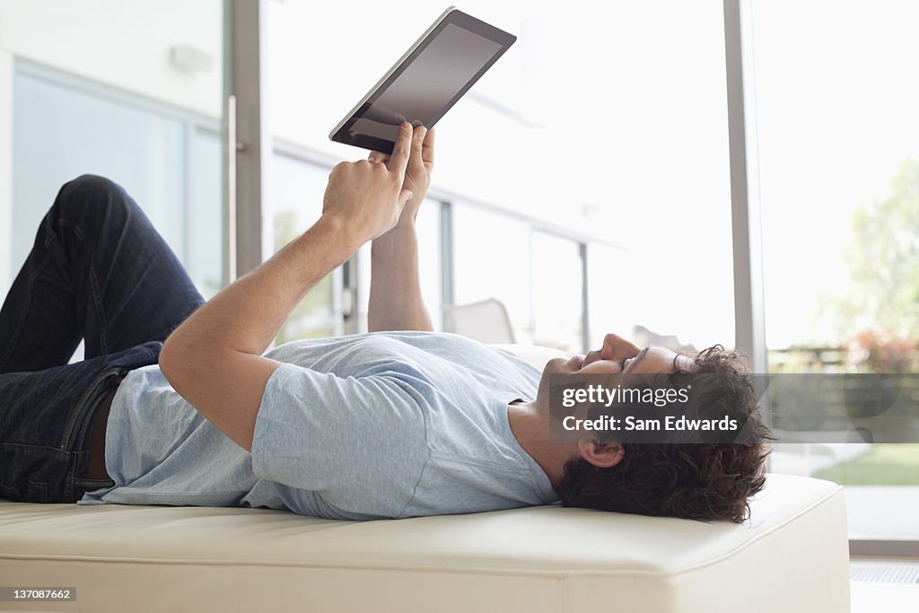 Man laying down using digital tablet