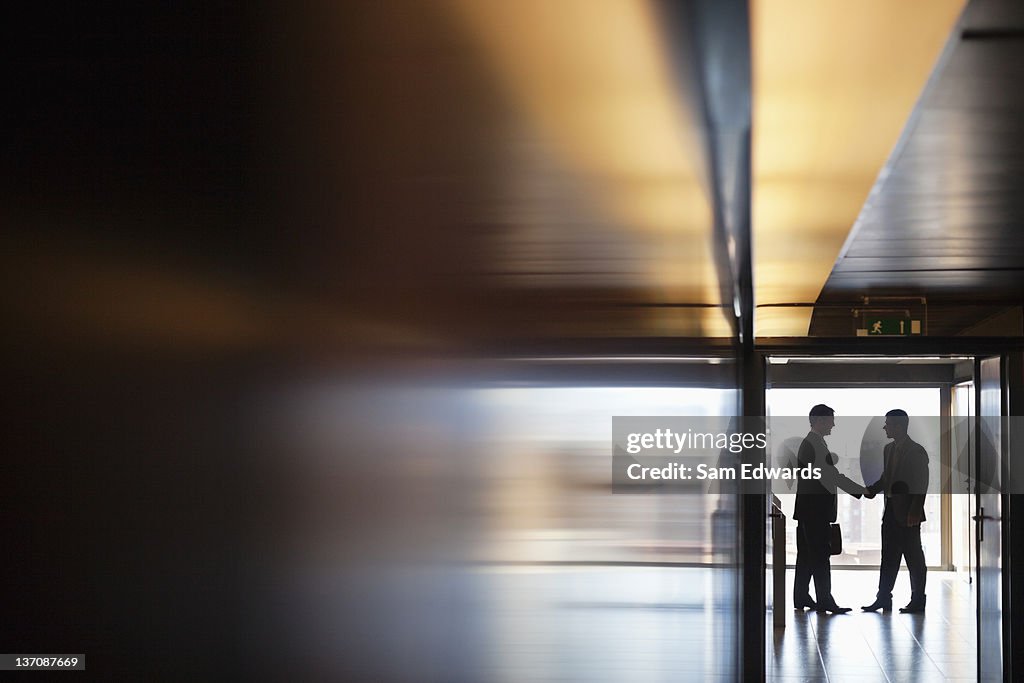 Empresário agitando mãos no corredor