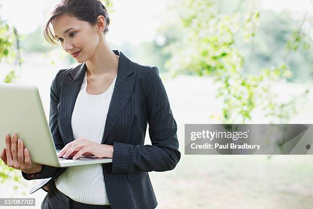 businesswoman using laptop outdoors - northants stock pictures, royalty-free photos & images