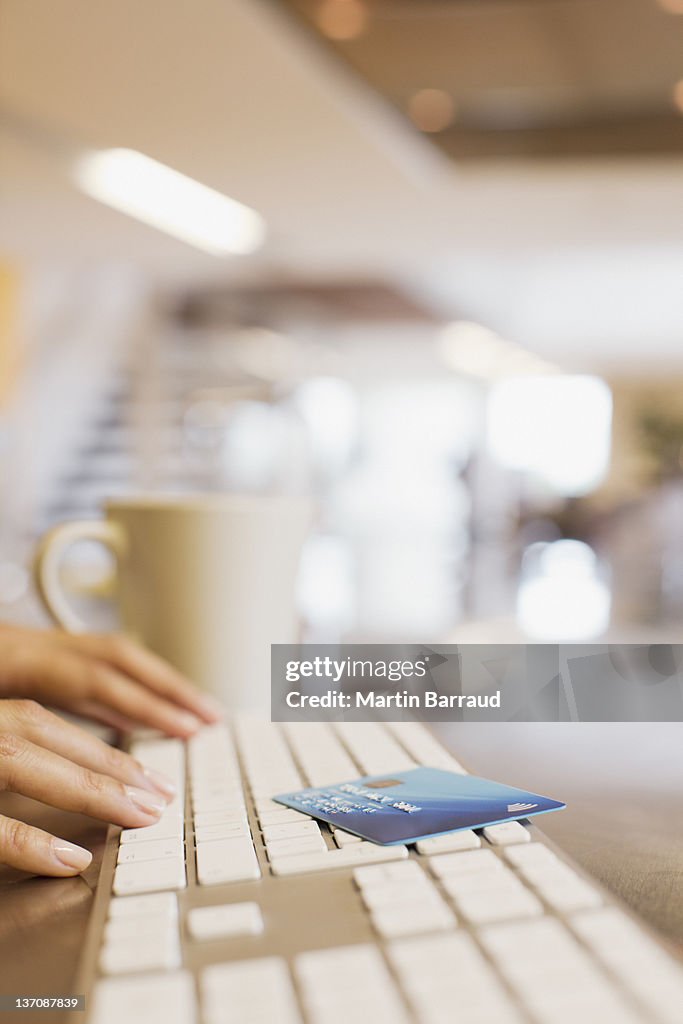 Close up of woman credit card and woman typing on keyboard