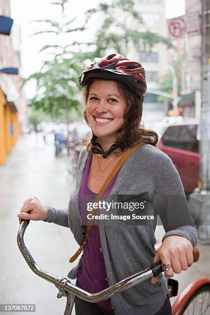 mujer joven usando un casco, sonriente ciclo - casco de ciclista fotografías e imágenes de stock