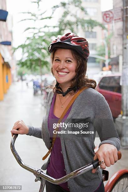 mujer joven usando un casco, sonriente ciclo - casco fotografías e imágenes de stock