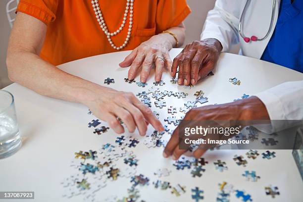 mulher idosa e médico com quebra-cabeça - puzzle imagens e fotografias de stock