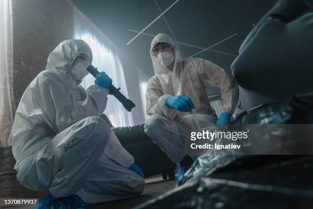 criminologists in protective suits at the crime scene in abandoned warehouse squatting near the dead body - gory of dead people stock pictures, royalty-free photos & images