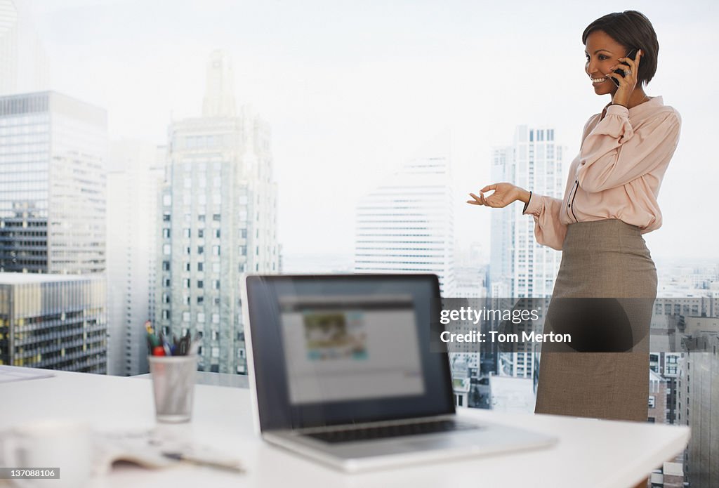 Businesswoman talking on cell phone in office