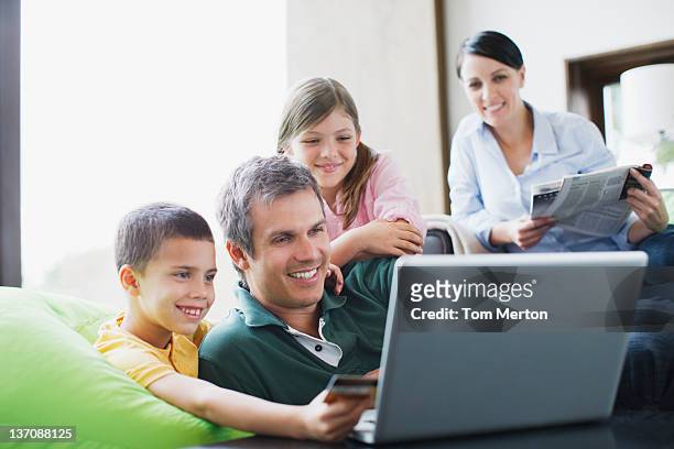 family using laptop together - family home internet stockfoto's en -beelden