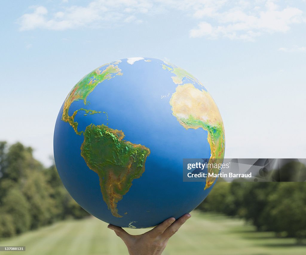 Mão segurando grandes globo ao ar livre