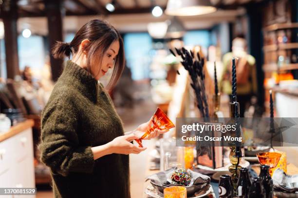 young woman shopping gifts for family and friends in department store - cushion stock photos et images de collection