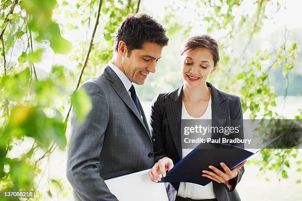 business people looking at report together outdoors - man check suit stock pictures, royalty-free photos & images