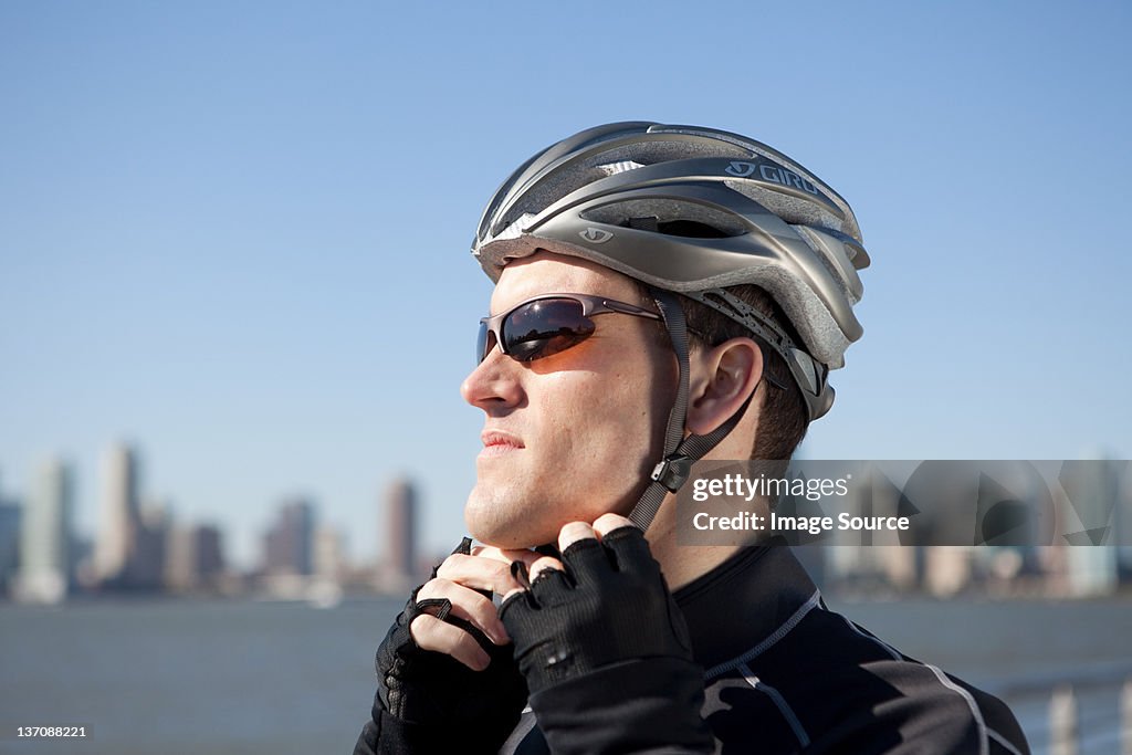 Man adjusting bike helmet strap