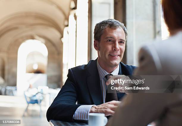 businessmen having coffee in sidewalk cafe - two executive man coffee shop stock pictures, royalty-free photos & images