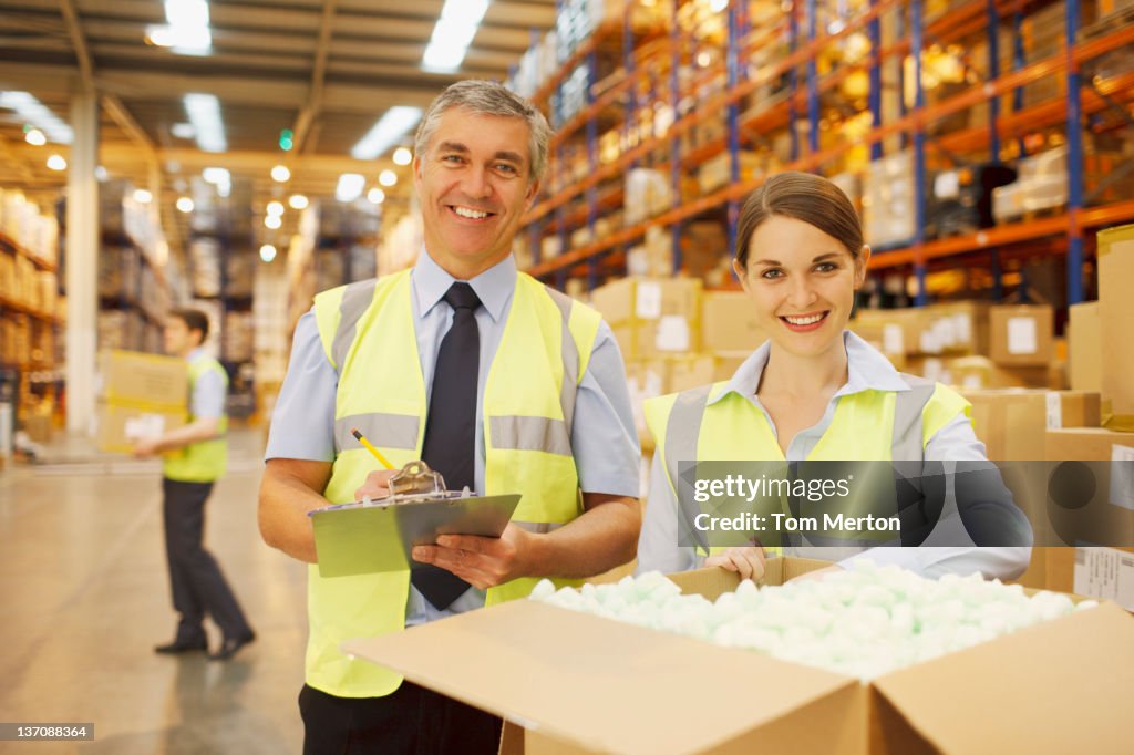 Workers in warehouse standing near box