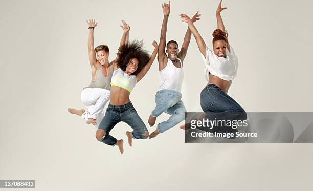 four young adults jumping in the air with joy - live in levis event stock pictures, royalty-free photos & images