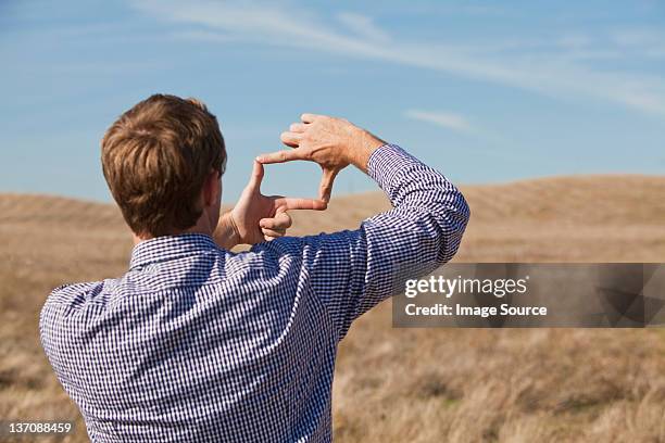 man using hands to frame landscape - quadrado com dedos imagens e fotografias de stock