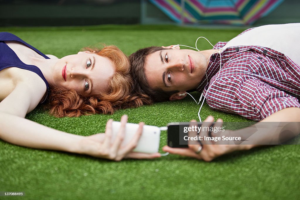 Couple lying down looking at mobile phones