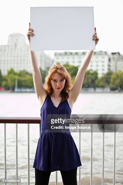 young woman holding up a white message board - placa de manifestação - fotografias e filmes do acervo