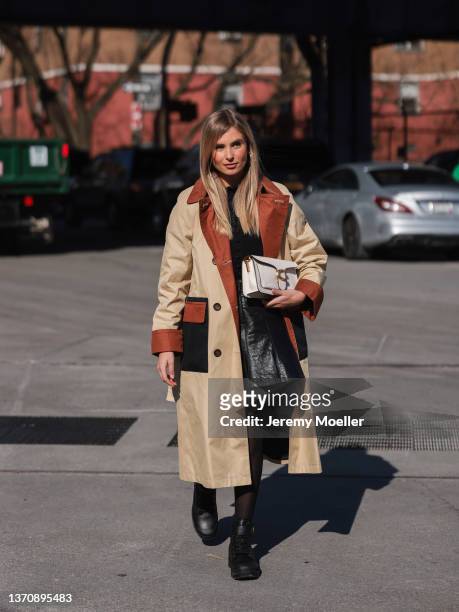 Xenia Adonts is seen wearing a tan Coach trench coat outside the Coach show during New York Fashion Week A/W 2022 on February 14, 2022 in New York...