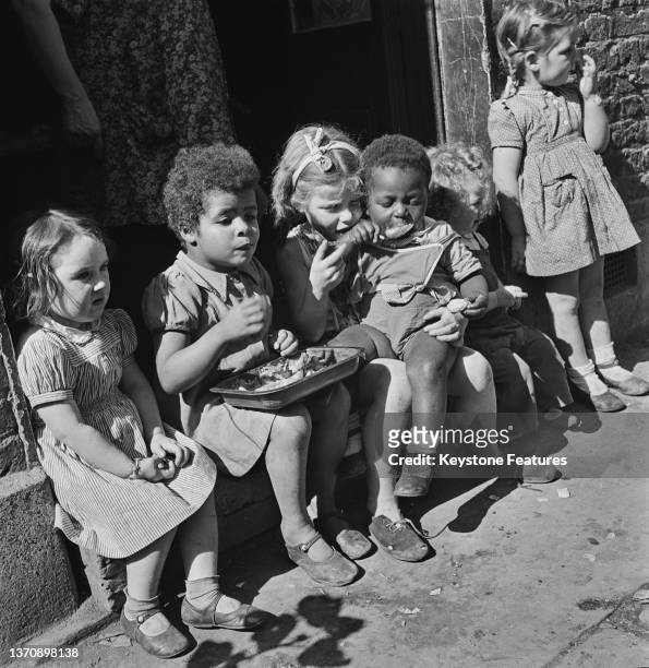 Children enjoying a snack outdoors provided by their foster mother, Mrs Wheeler, Kilburn, London, UK, 1948; they are Kay Breeze, Ann Bellow,...