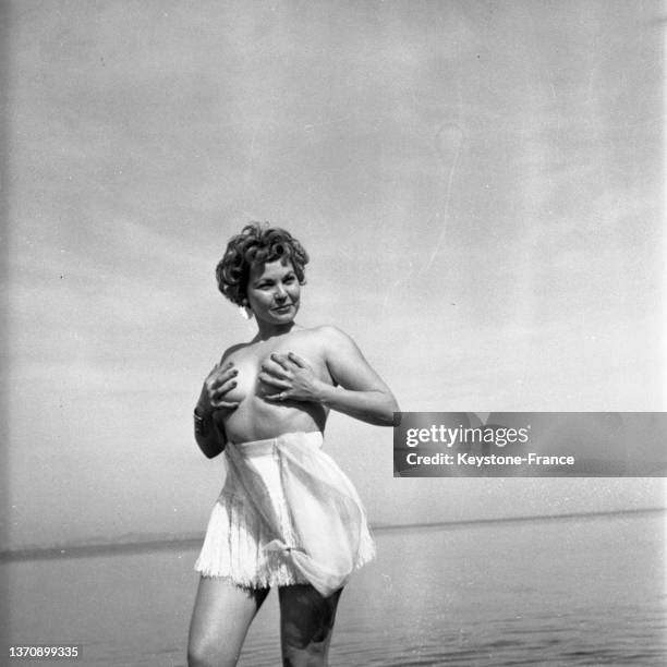 Simone Silva posant seins nus sur la plage lors du Festival de Cannes, en avril 1954.