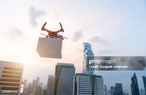 delivery drone flying in city - aerial surveillance stock pictures, royalty-free photos & images