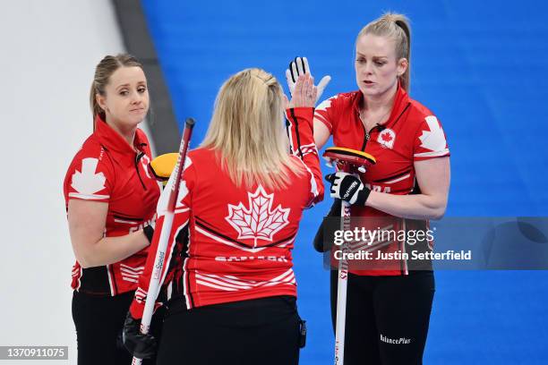 Jocelyn Peterman, Jennifer Jones and Dawn McEwen of Team Canada interact while competing against Team China during the Women's Round Robin Session on...