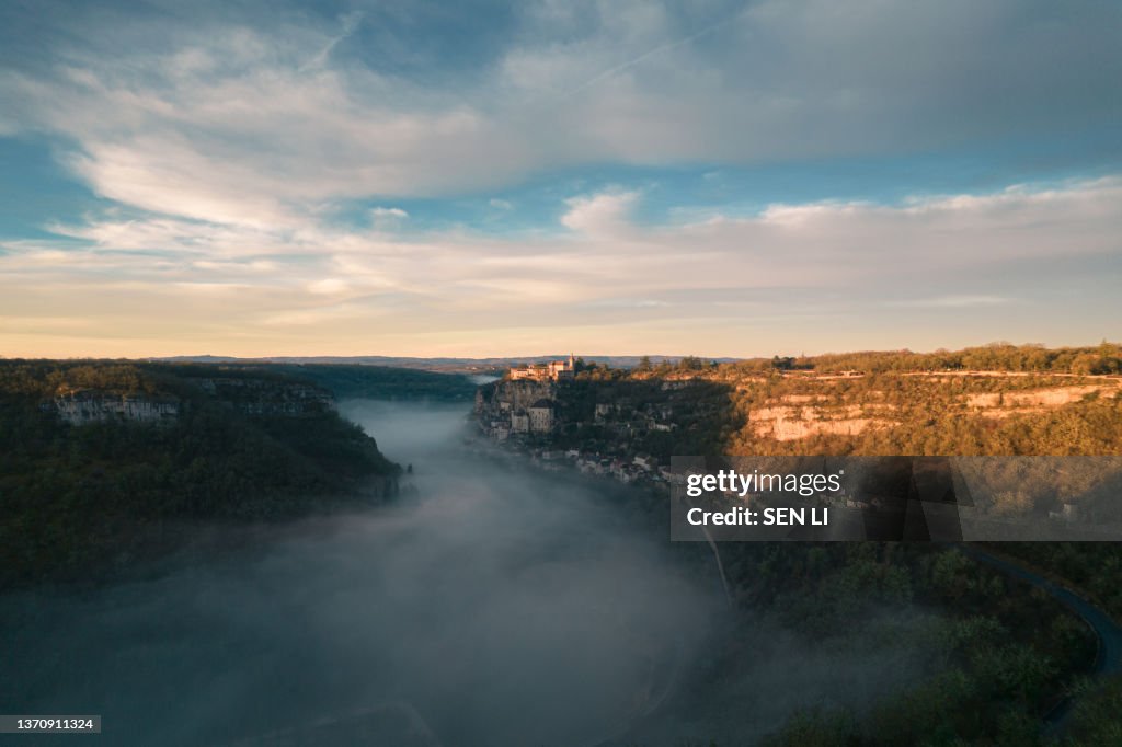 Rocamadour sunrise, Aerial view of the french village and castle on cliff in early morning with fogs in the Canyon of the Alzou
