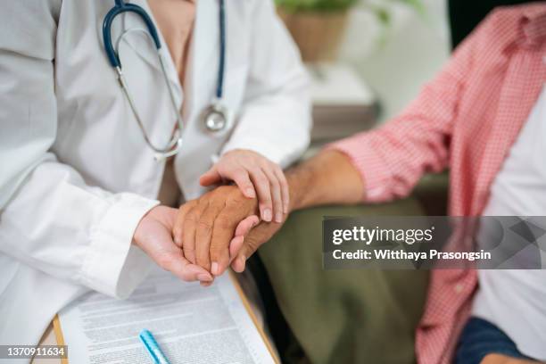 health care concept with geriatric doctor consulting examining elderly senior aged adult in medical exam clinic or hospital - womans clinic heart stockfoto's en -beelden