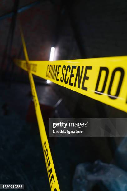 crime scene tape barrier in front of defocused background - crime scene stockfoto's en -beelden