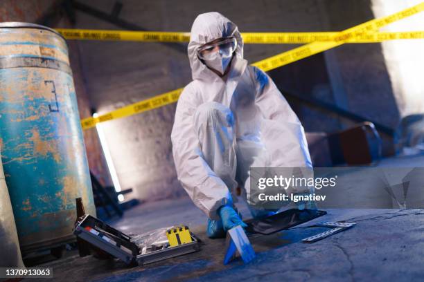 criminólogo contra la cinta de barricada en la escena del crimen trabajando con evidencias físicas - asesino fotografías e imágenes de stock
