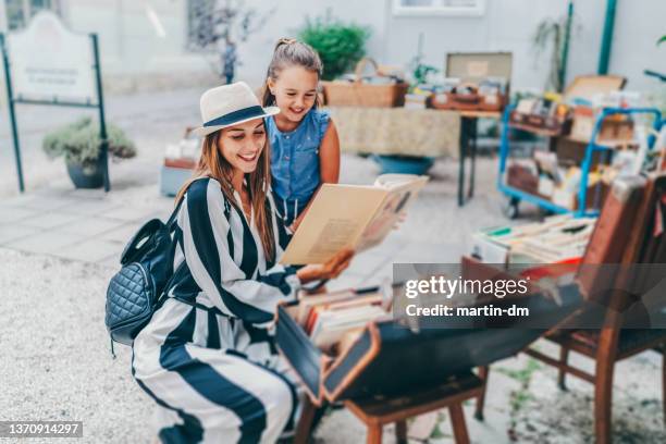 mother and daughter choosing book from an old bookstore - hungary summer stock pictures, royalty-free photos & images