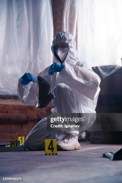 criminologist at the crime scene with physical evidence in a plastic bag - forsaken film stockfoto's en -beelden