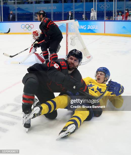 David Desharnais of Team Canada and Pontus Holmberg of Team Sweden collide in the third period during the Men’s Ice Hockey Quarterfinal match between...