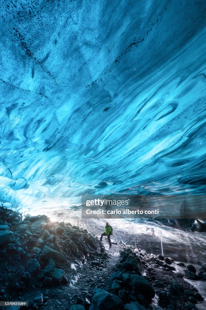 One hiker admire the Icelandic Ice Cave, Iceland