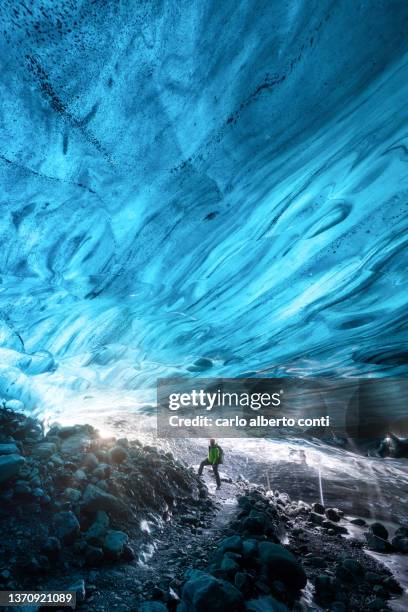 one hiker admire the icelandic ice cave, iceland - ice cave stock pictures, royalty-free photos & images